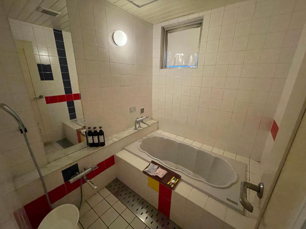 une salle de bain avec baignoire et toilettes dans l'établissement Hotel Luxe - Adult Only, à Tokyo