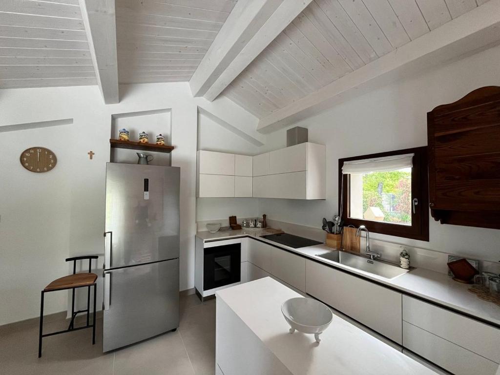 Il comprend une cuisine équipée d'un réfrigérateur en acier inoxydable et une fenêtre. dans l'établissement Poggio Ancisa Relais, à Casteldelci