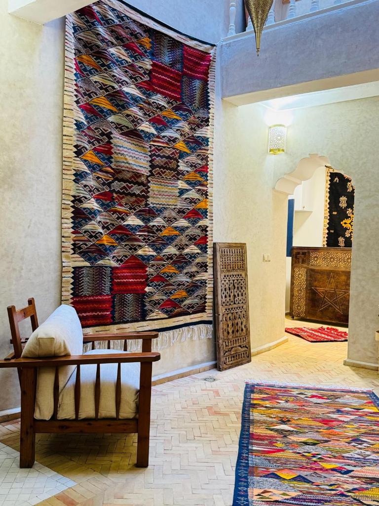 une pièce avec un banc et un mur avec un tapis dans l'établissement Riad Babette, à Essaouira