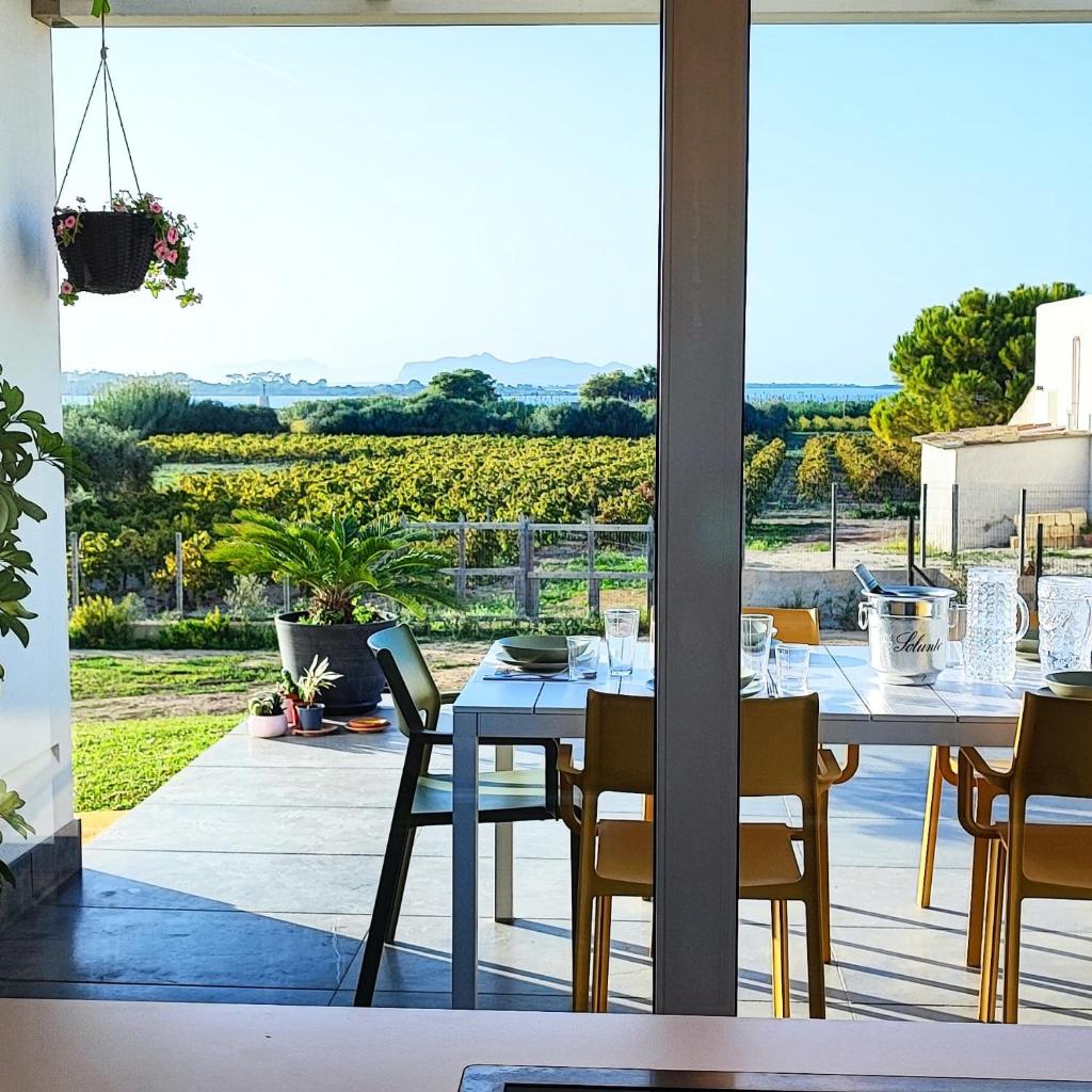 une salle à manger avec une table et une vue sur un vignoble dans l'établissement Martina's Vineyard - villa, à Marsala