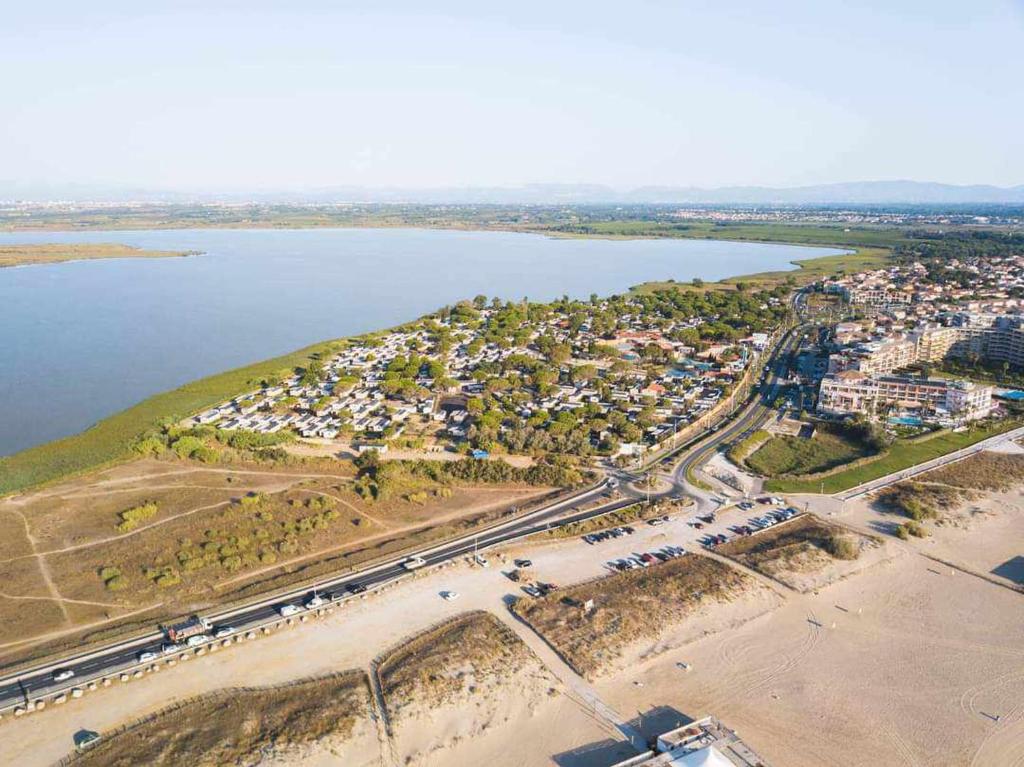 une vue aérienne sur un parking situé à côté d'une masse d'eau dans l'établissement Mobil-home, à Canet