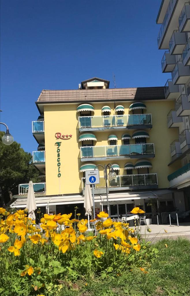 un bâtiment avec un bouquet de fleurs jaunes devant dans l'établissement Appartamenti Residence Foscolo, à Lido di Jesolo