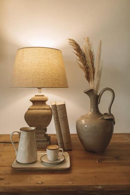 une table avec une lampe, un vase et une tasse de café dans l'établissement Wine Resort Campacci, à San Gusmè