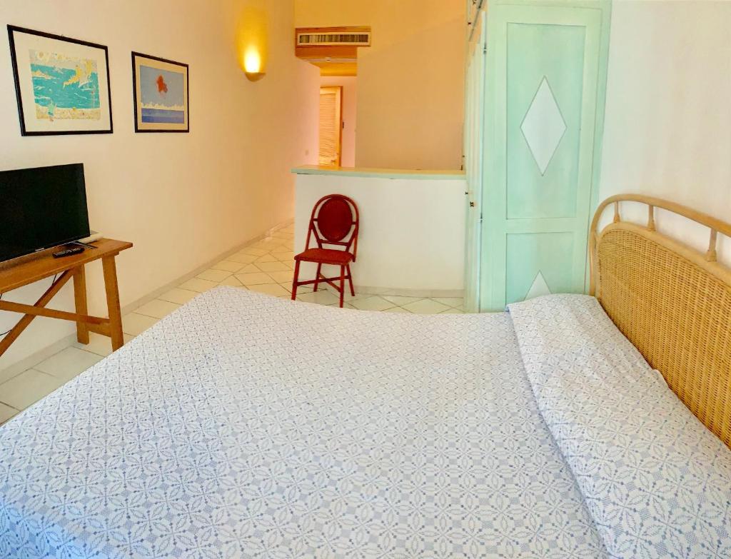 une chambre avec un lit, un bureau et une télévision dans l'établissement Swadeshi Sporting Hotel Tanca Manna, à Cannigione 30 autres photos