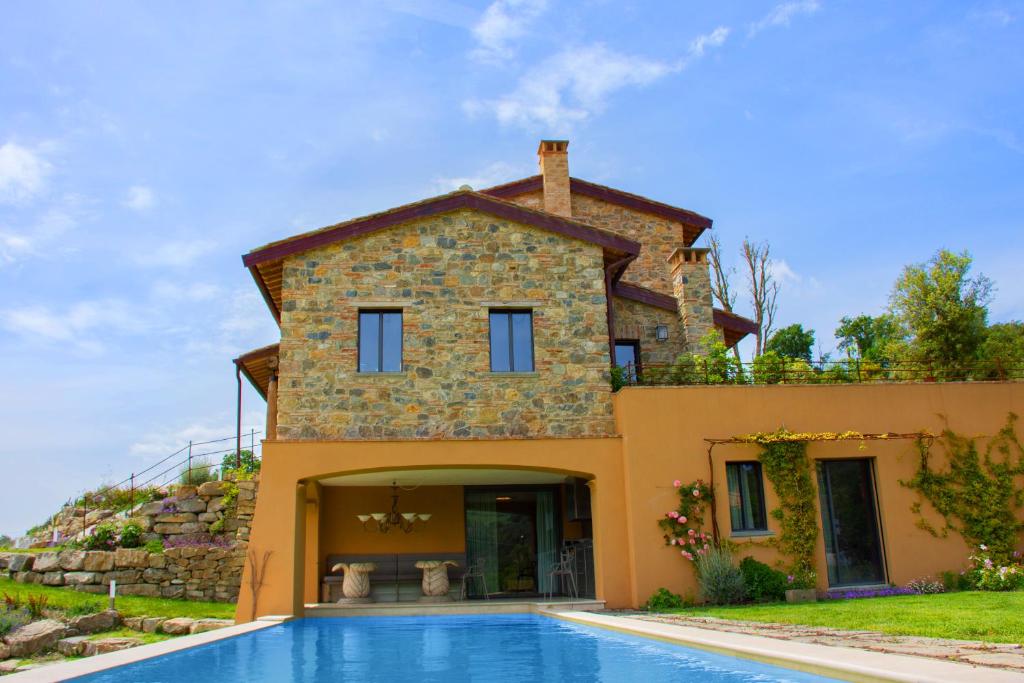 une villa avec piscine devant une maison dans l'établissement Villa le Sughere - Privacy, Piscina e Vista Panoramica, à Castellina Marittima