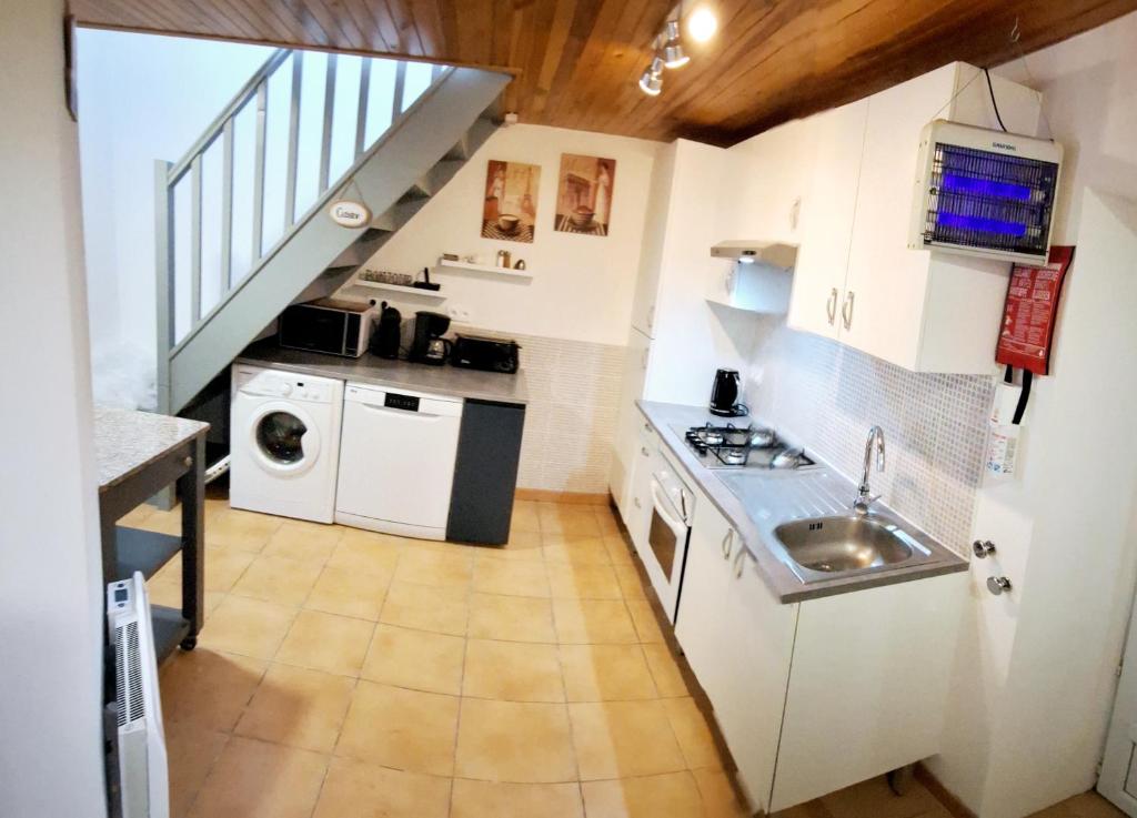 une petite cuisine avec des armoires blanches et un évier dans l'établissement Le Jarrier Gite - Alpes Mancelles, à Saint-Georges-le-Gaultier