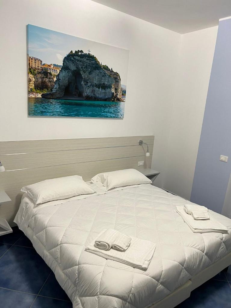 une chambre avec un lit avec un tableau sur le mur dans l'établissement Hotel La Giara, à Zambrone