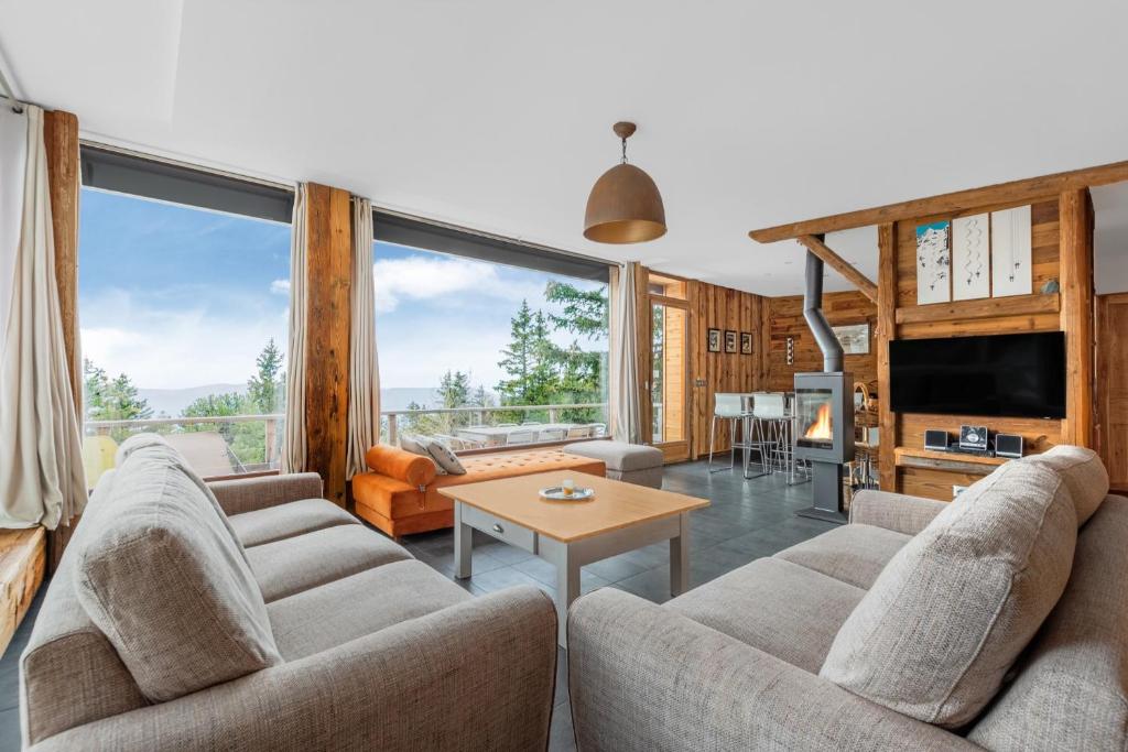un salon avec deux canapés et une table dans l'établissement Grand Chalet Standing Avec Jacuzzi à Chamrousse ski 1750, à Chamrousse