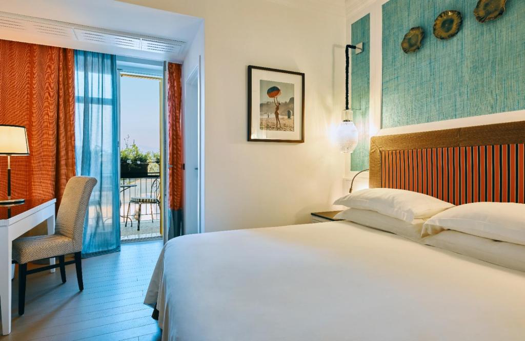 une chambre d'hôtel avec un lit, un bureau et une fenêtre dans l'établissement Boutique Hotel Esplanade, à Paestum