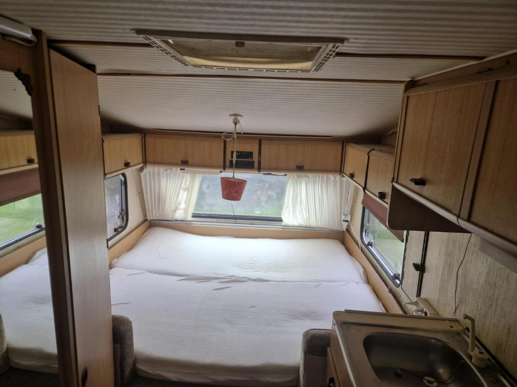- un petit lit à l'arrière d'un véhicule dans l'établissement Camping La Foret du Morvan Caravan Joost, à Larochemillay