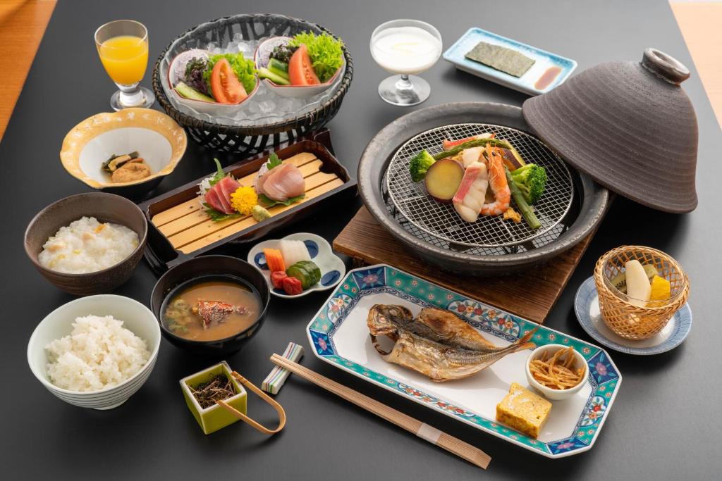 une table recouverte de plaques alimentaires et de bols de riz dans l'établissement Omuro no Mori Gyokusui -Adult Only-, à Itō