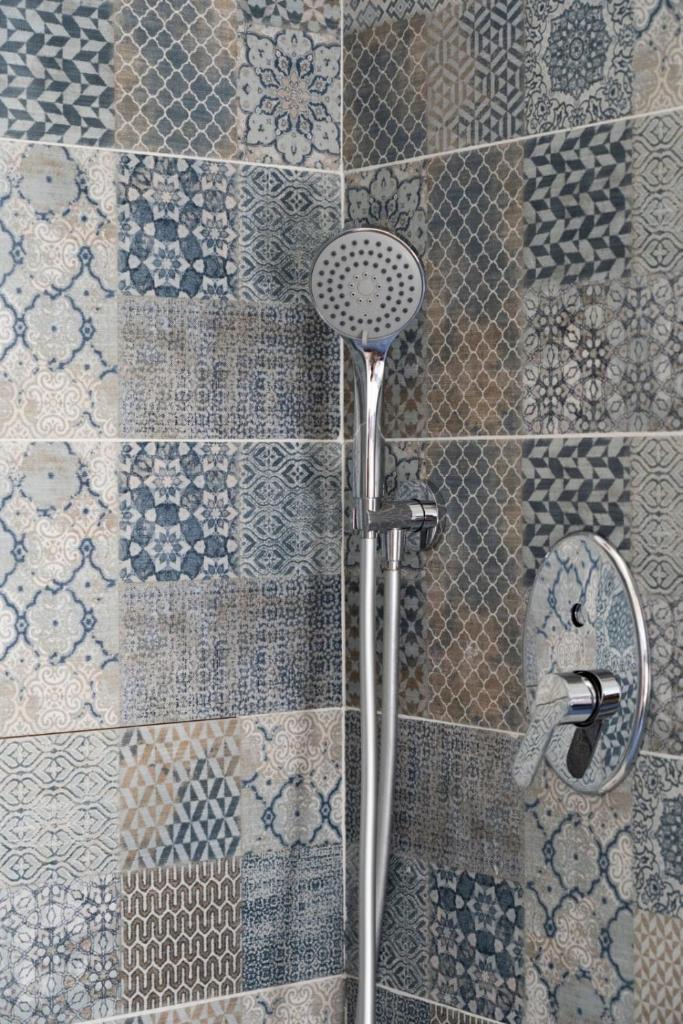 une douche dans une salle de bain avec un mur carrelé dans l'établissement La Giara - Villa with Swimming Pool and Parking, à Castellammare del Golfo