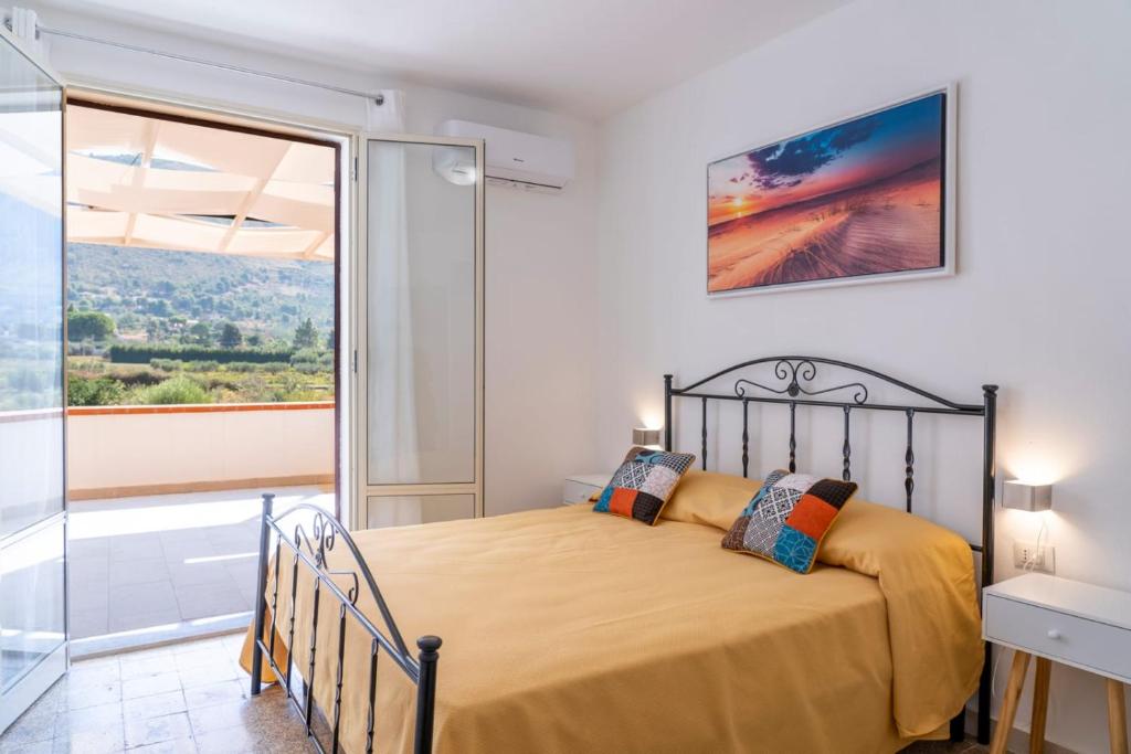 une chambre avec un lit et un balcon dans l'établissement La Giara - Villa with Swimming Pool and Parking, à Castellammare del Golfo