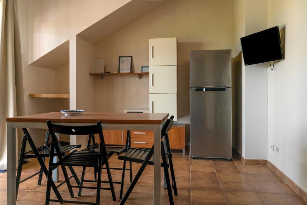 une cuisine avec une table et un réfrigérateur dans l'établissement Agua Residence, à Noto 10 autres photos