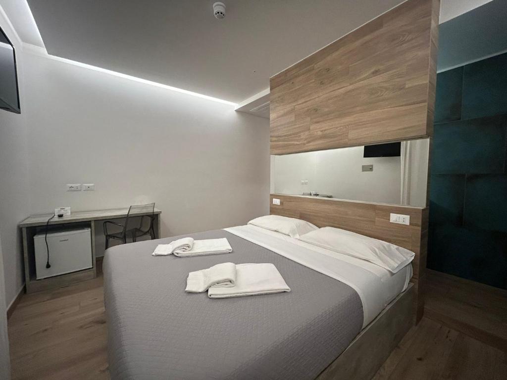 une chambre avec un grand lit avec des serviettes dessus dans l'établissement Hotel Neps, à Lido di Jesolo