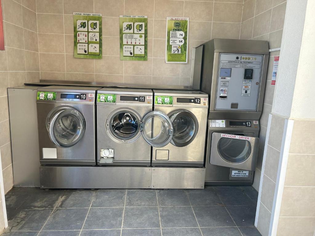 - deux lave-linge et un lave-linge/sèche-linge dans une pièce dans l'établissement Camping la palmeraie 4* mobil home 3 chambres-6personnes, à Torreilles