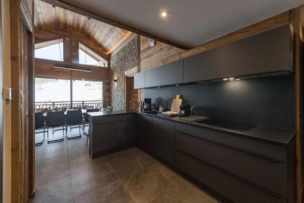 une cuisine avec des armoires noires et un comptoir dans l'établissement Appartement de standing 12 personnes au pied des pistes - Olvera 602, à Valmeinier 17 autres photos