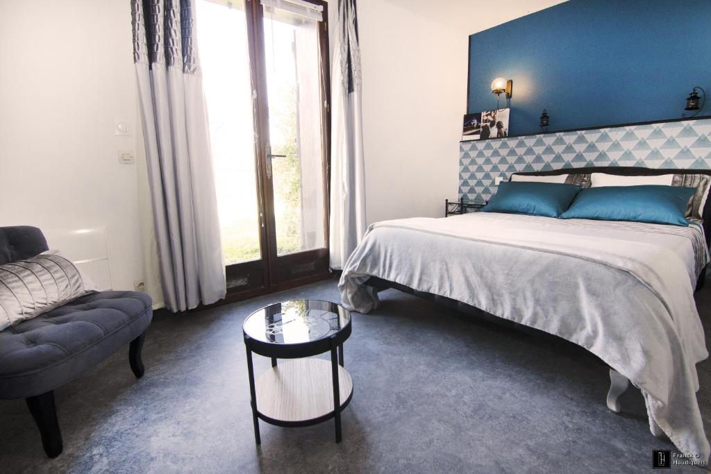 une chambre avec un lit, un canapé et une table dans l'établissement Maison des Soupirs, à Montpon-Ménestérol