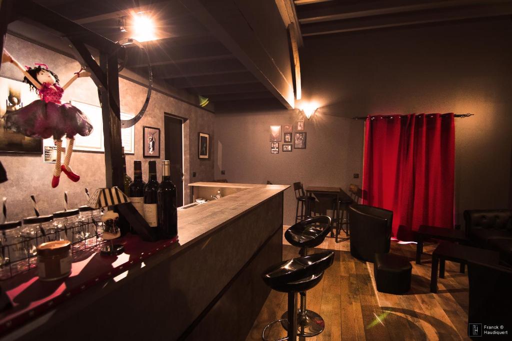 - un bar avec un comptoir avec des bouteilles de vin dans l'établissement Maison des Soupirs, à Montpon-Ménestérol