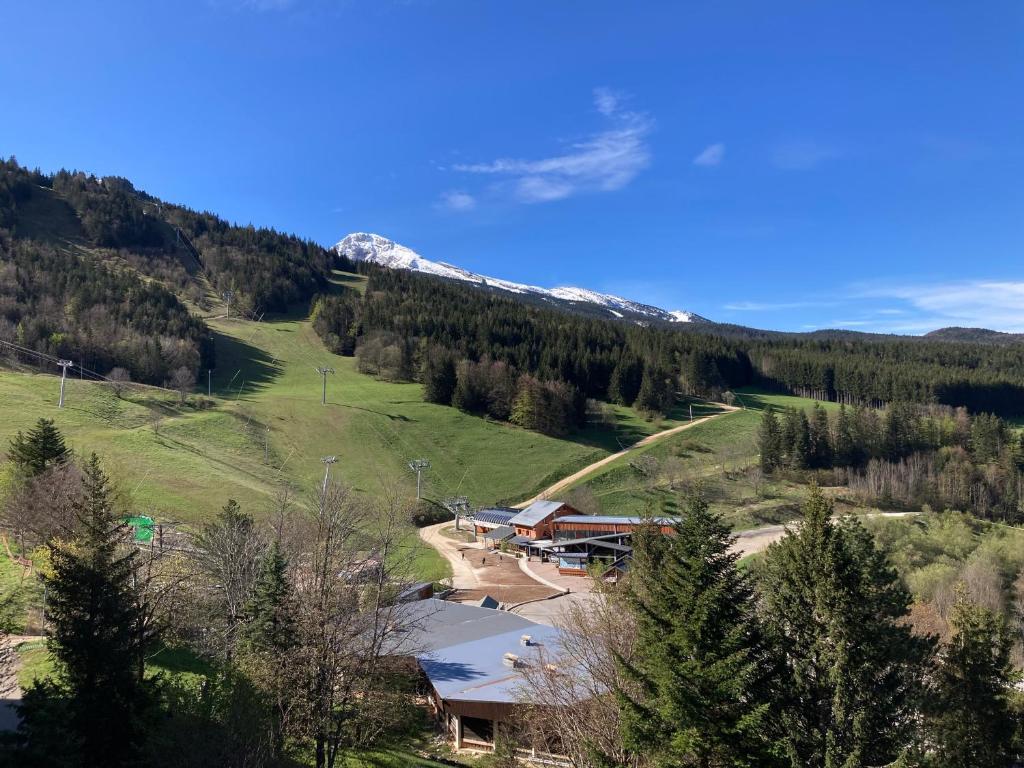 une maison sur une colline avec une montagne enneigée dans l'établissement Au pied des pistes Côte 2000 - Le Balcon de Villard de Lans, à Villard-de-Lans