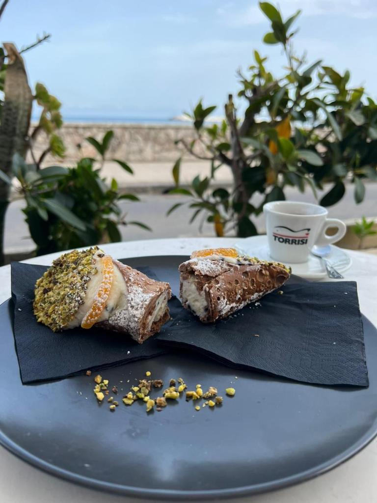 deux morceaux de nourriture sur une assiette bleue avec une tasse de café dans l'établissement LUXURY, VILLA VITTORIO, Pool, Taormina,Etna & Seaview, à Giardini Naxos