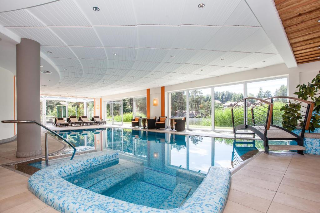 une piscine intérieure avec une grande visière dans l'établissement Hotel Am Wolfgrubenersee, à Soprabolzano