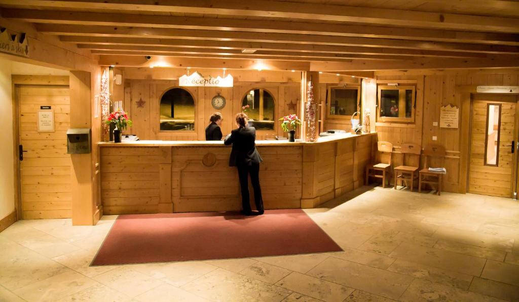 une femme debout devant un comptoir de salle de bains dans l'établissement Les Alpages De Val Cenis, à Lanslebourg-Mont-Cenis 26 autres photos