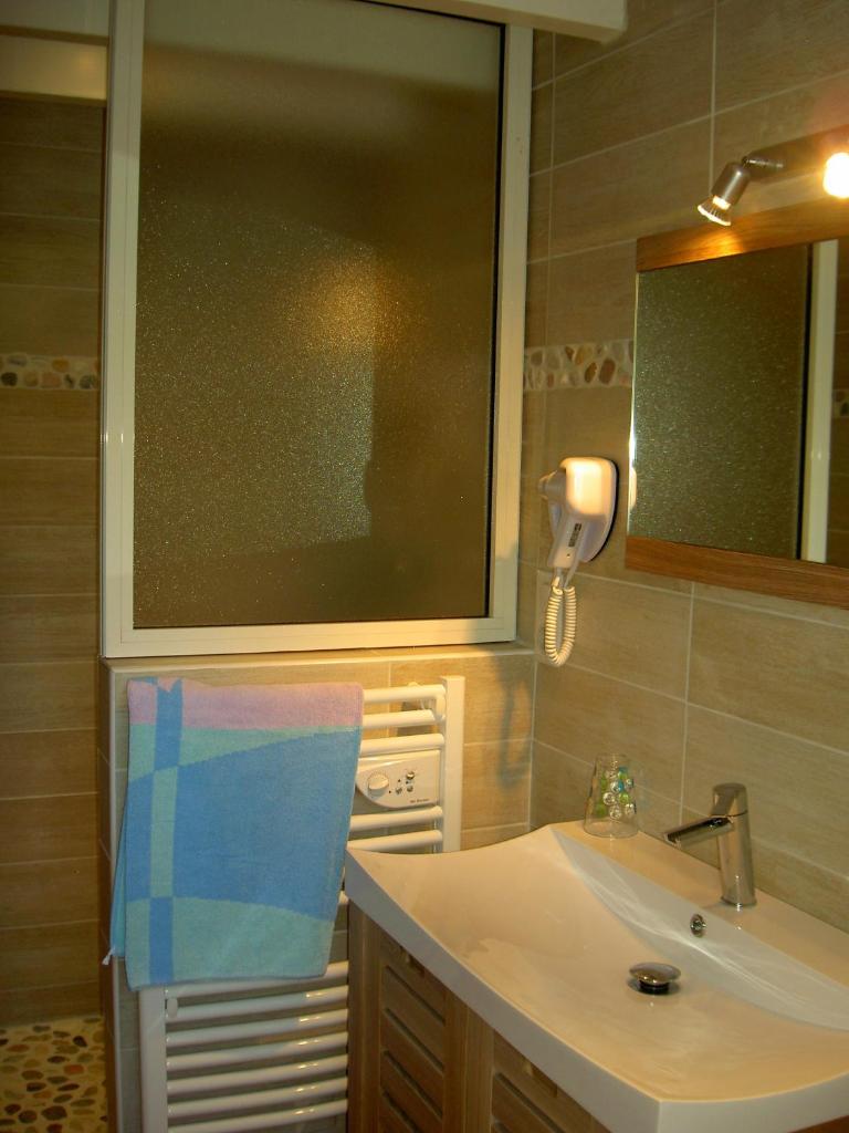 une salle de bain avec un lavabo et un miroir dans l'établissement Gîtes de La Palombière, à Les Eyzies-de-Tayac