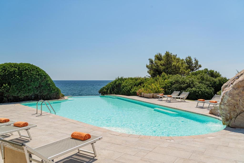 une piscine avec vue sur l'océan dans l'établissement Hotel Punta Negra, à Alghero