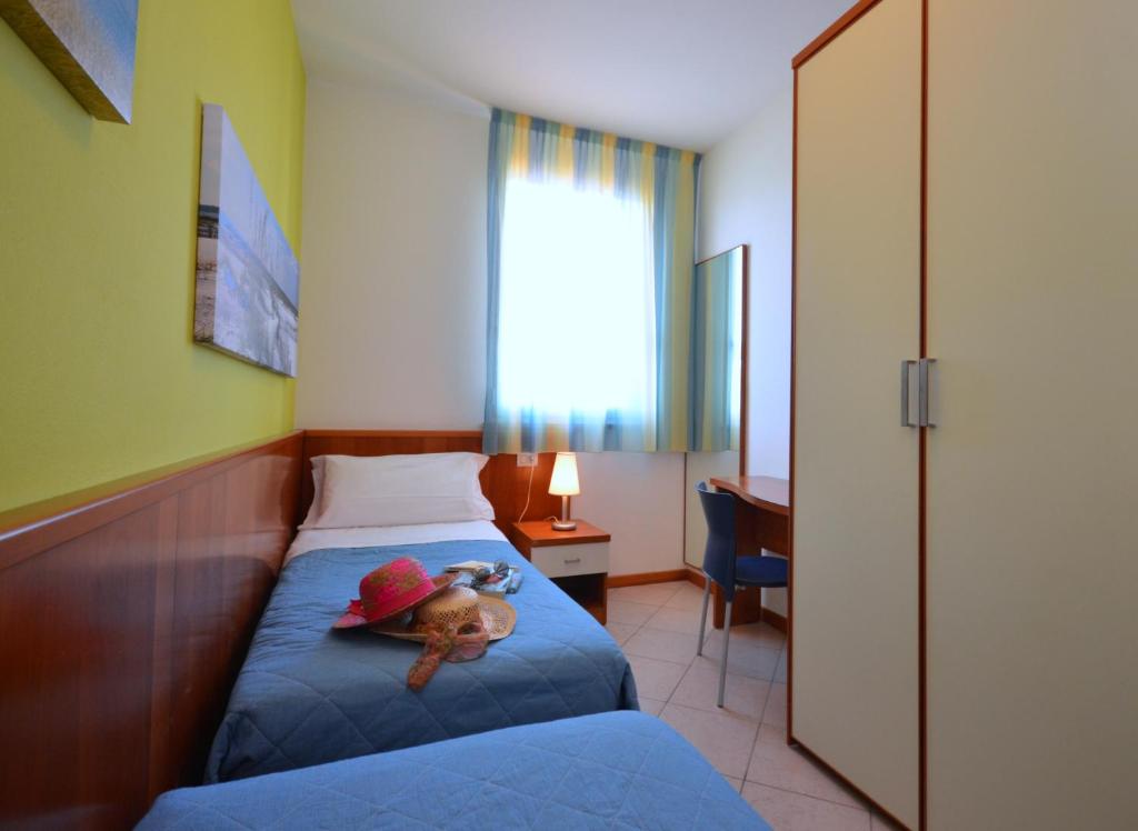 une petite chambre avec un ours en peluche posé sur un lit dans l'établissement Villaggio Marco Polo, à Bibione