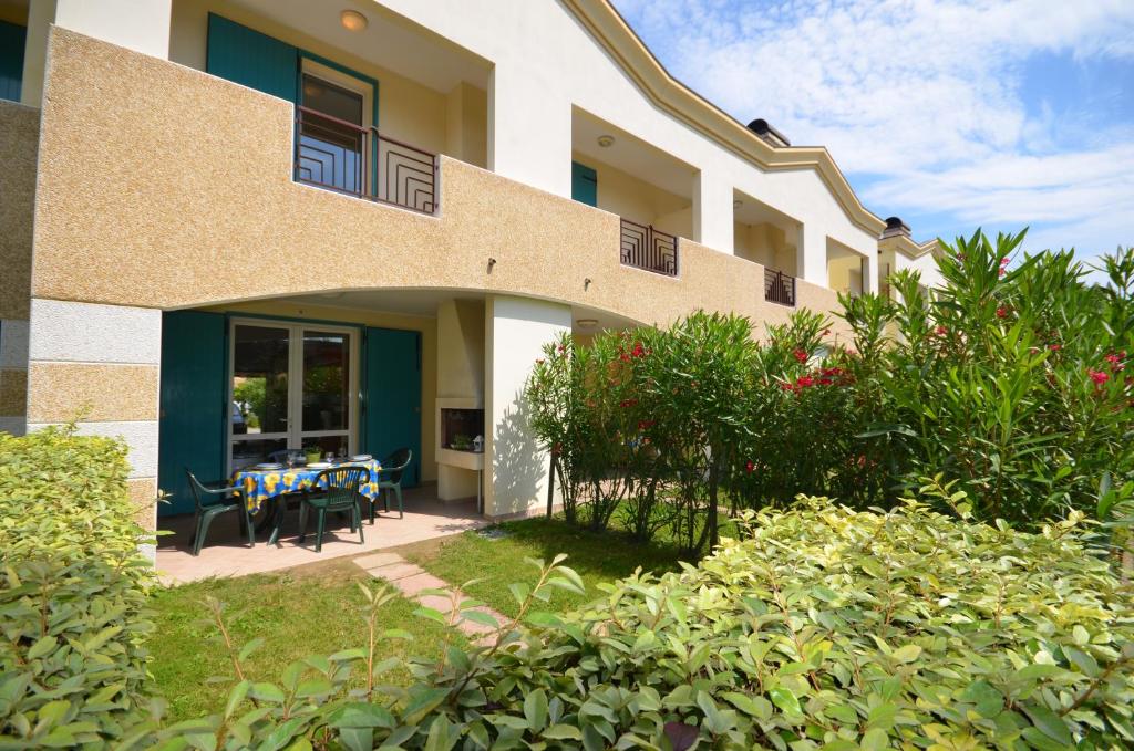 - un bâtiment avec une terrasse dotée de tables et de chaises dans l'établissement Villaggio Marco Polo, à Bibione