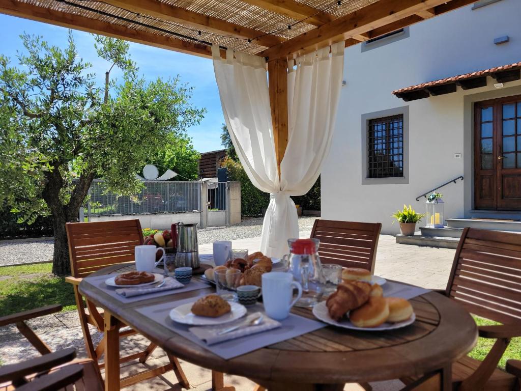 - une table en bois avec du pain et des viennoiseries dans l'établissement Dimora F F Famiglia Fanucchi, à Lucques