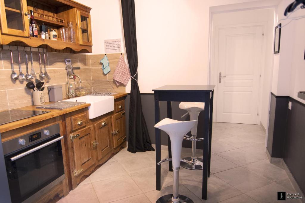 une cuisine avec un comptoir et une table à l'intérieur dans l'établissement Maison des Soupirs, à Montpon-Ménestérol