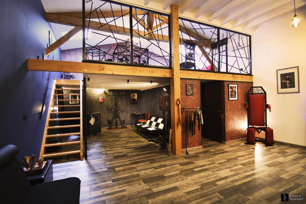 une chambre avec une mezzanine avec un canapé et un escalier dans l'établissement Maison des Soupirs, à Montpon-Ménestérol