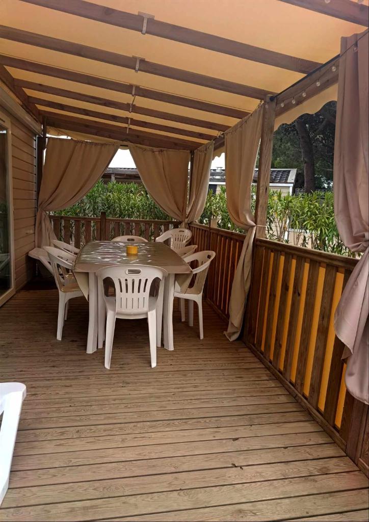 un patio avec une table et des chaises sur une terrasse dans l'établissement Mobil-home, à Canet