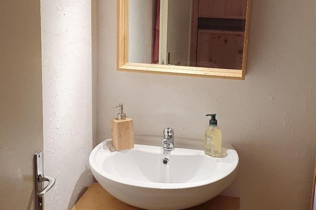 un lavabo blanc dans une salle de bain avec un miroir dans l'établissement Studio tout confort aux Balcons de Villard de Lans, à Villard-de-Lans