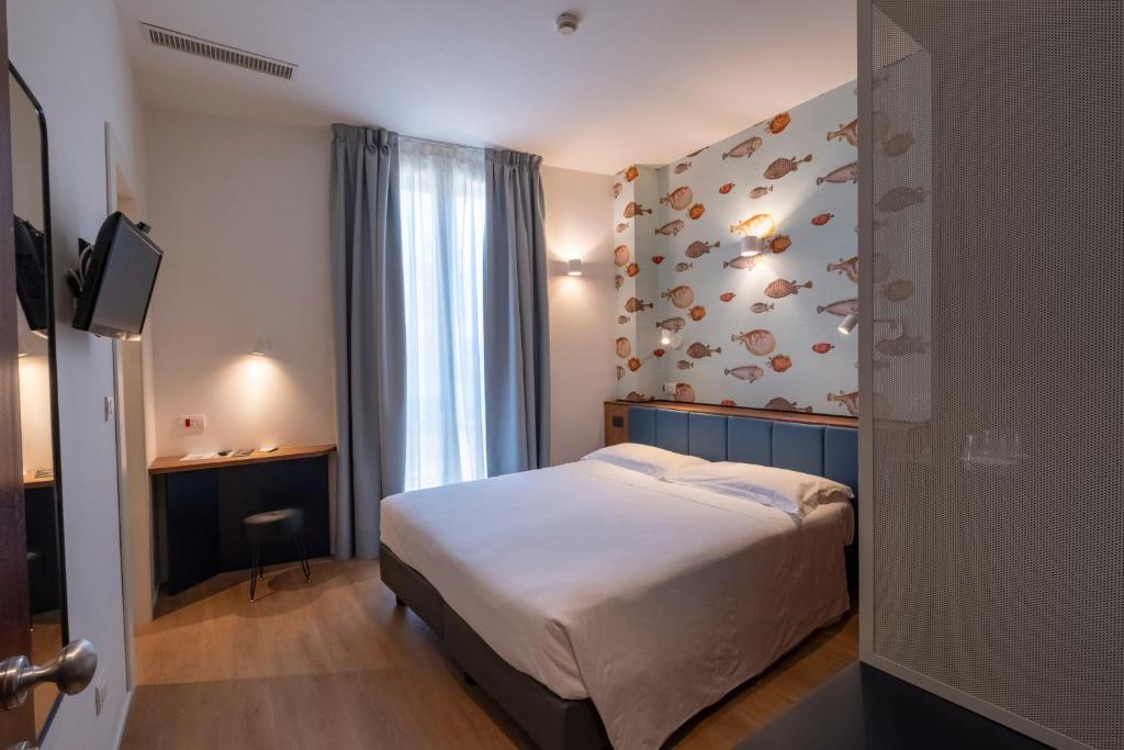 une chambre d'hôtel avec un lit et un mur avec des papillons dans l'établissement Hotel Italia e Lido Rapallo, à Rapallo
