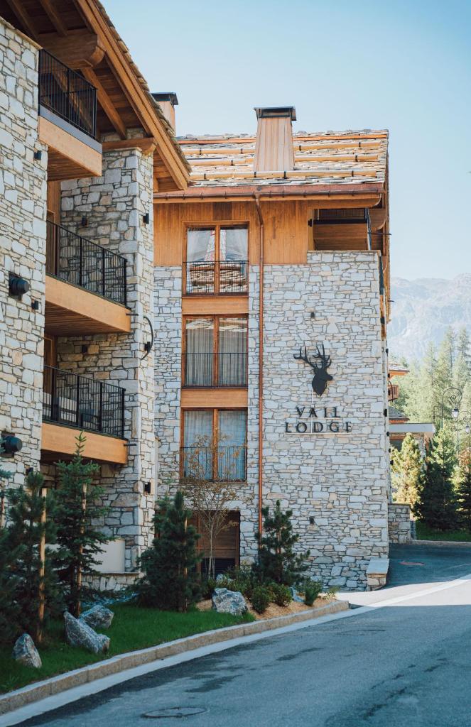 un bâtiment avec un panneau de loge sur le côté dans l'établissement Vail Lodge by Alpine Resorts, à Val dʼIsère