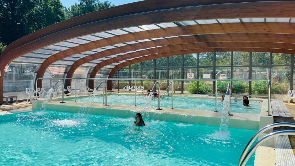 une piscine avec une personne dans l'eau dans l'établissement Mobilhome climatisé, 6 personnes camping les embruns, à Lège-Cap-Ferret 9 autres photos