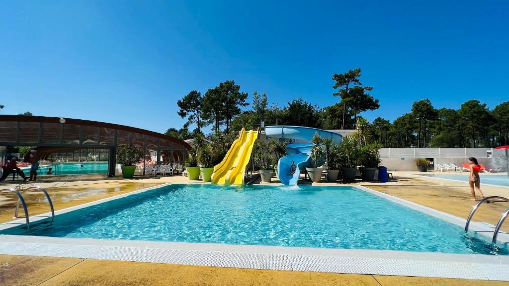une piscine avec toboggan et un parc aquatique dans l'établissement Mobilhome climatisé, 6 personnes camping les embruns, à Lège-Cap-Ferret