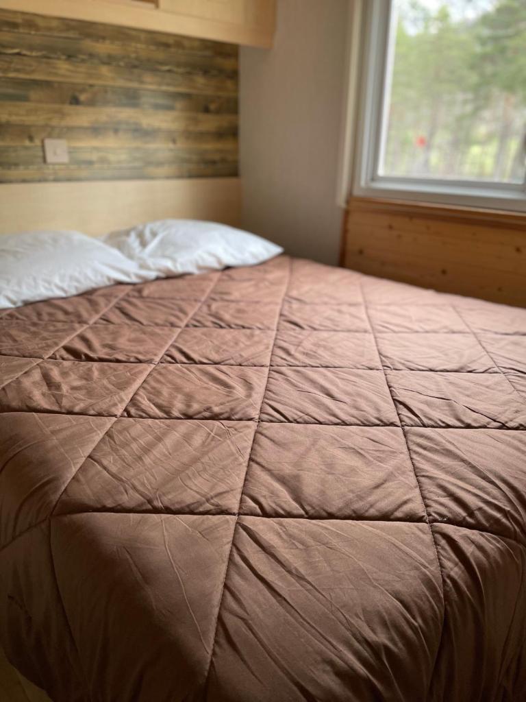 un grand lit dans une chambre avec une fenêtre dans l'établissement Le Nirvâna, à Saint-Auban