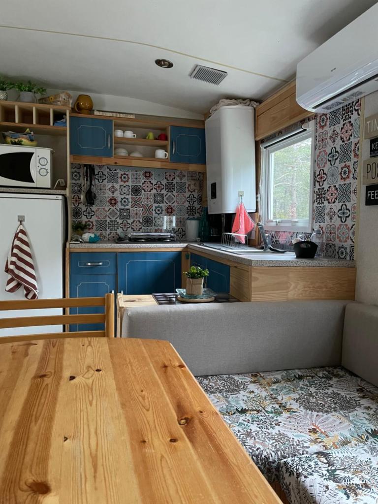 une cuisine avec des placards bleus et une table en bois dans l'établissement Le Nirvâna, à Saint-Auban