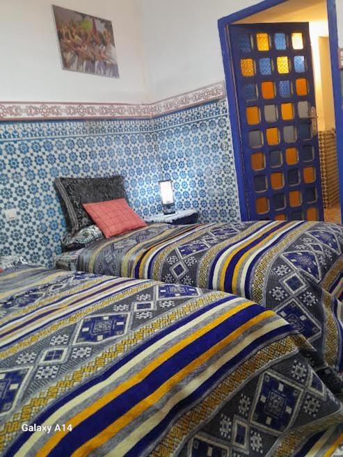 deux lits dans une chambre aux murs bleus dans l'établissement RIAD DAR KADER D, à Marrakech