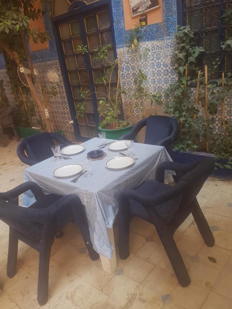 une table avec des chaises et un chiffon de table blanc dans l'établissement RIAD DAR KADER D, à Marrakech