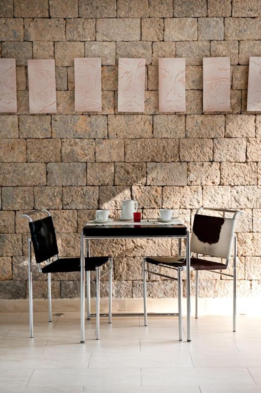une table et des chaises devant un mur de briques dans l'établissement Villa Santa Maria - Luxury Suites, à Amalfi