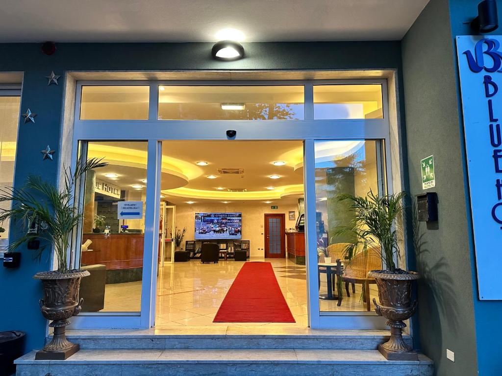 un hall d'entrée avec un tapis rouge devant une porte dans l'établissement Blue Loft Hotel, à Cesenatico