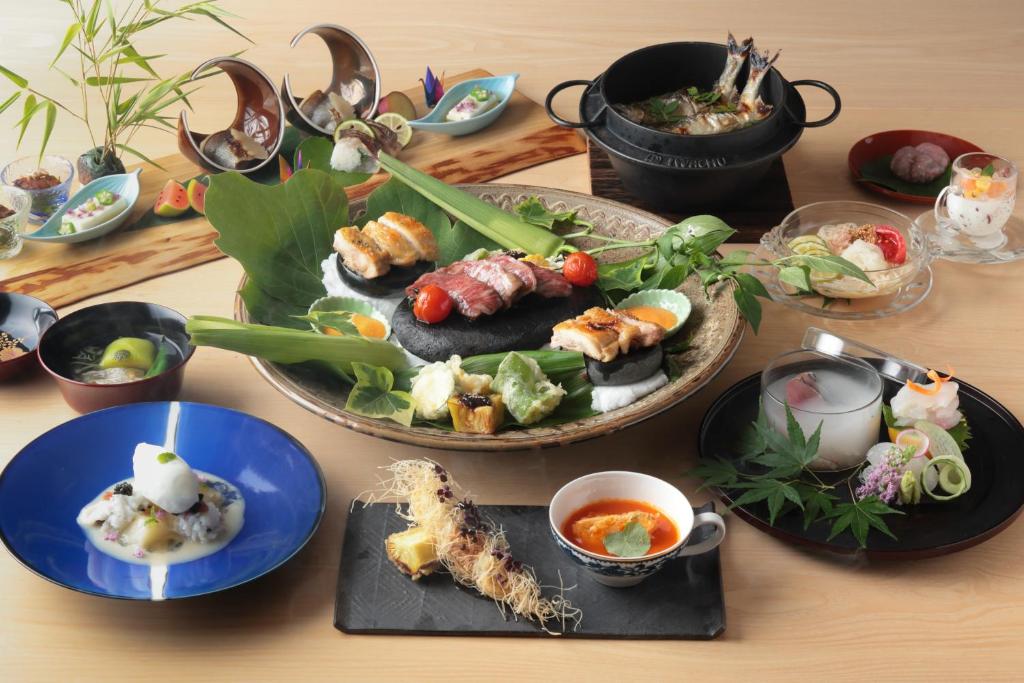 une table avec des assiettes de nourriture sur une table dans l'établissement Beppu Nagomitsuki, à Beppu