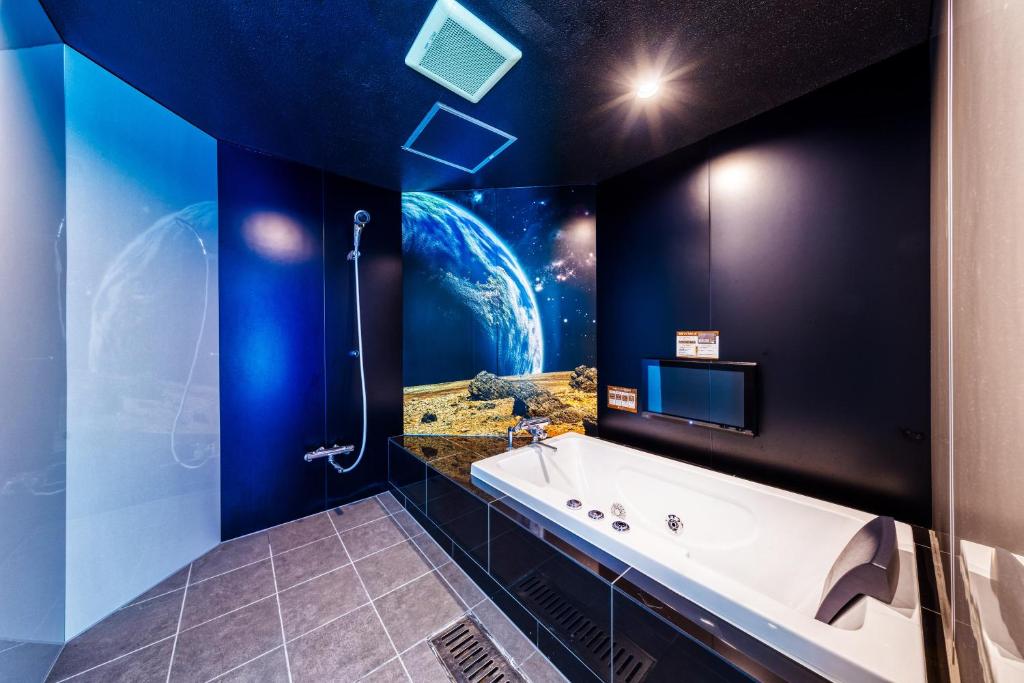 une salle de bain avec une grande baignoire et un télescope dans l'établissement Hotel Lotus Ibaraki -Adult Only, à Fukui