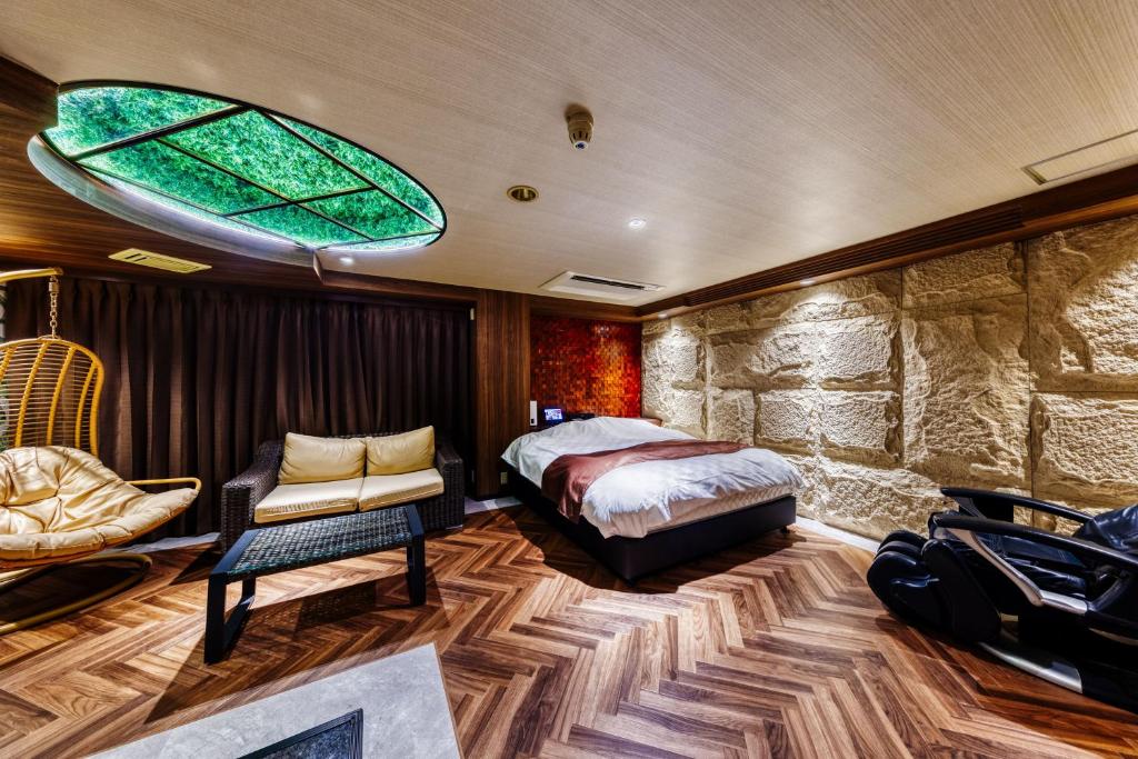 une chambre avec un lit, une chaise et une fenêtre dans l'établissement Hotel Lotus Ibaraki -Adult Only, à Fukui