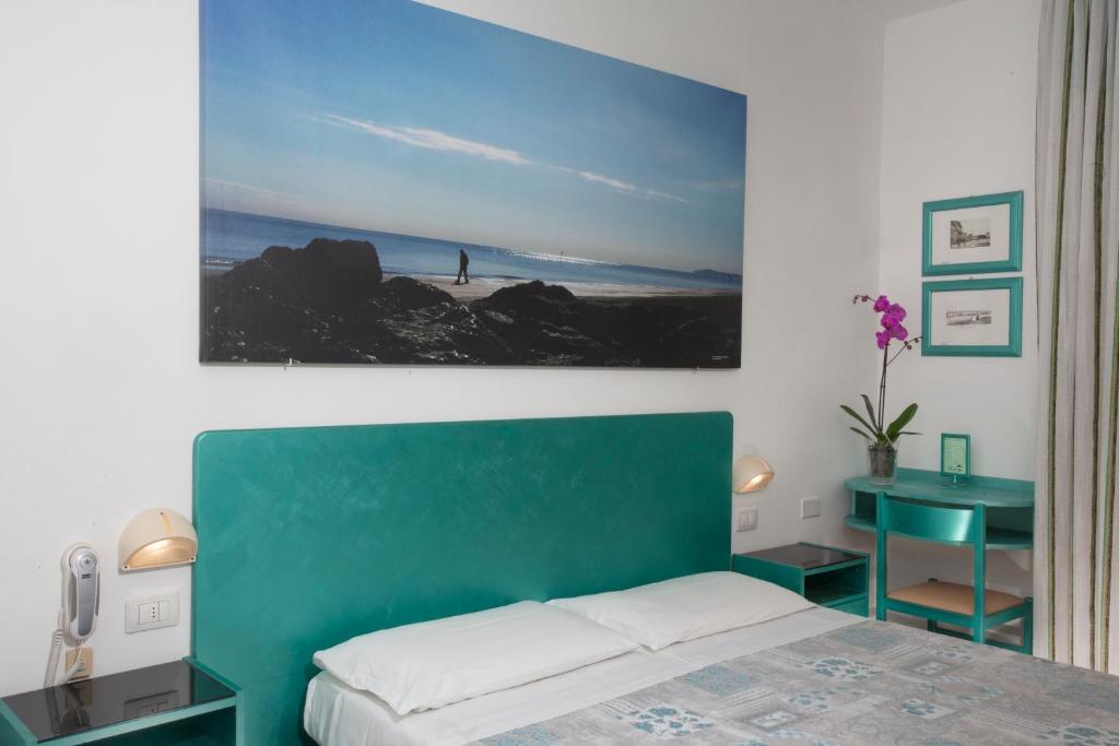 une chambre avec une tête de lit verte, un lit et une table dans l'établissement Hotel Marselli, à Rimini 70 autres photos